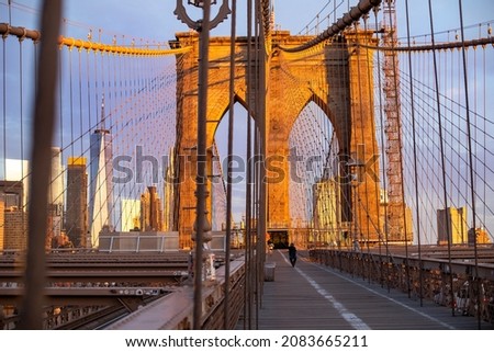 Vintage Brooklyn Bridge at magical sunrise with lower Manhattan in the background. Empty bridge with no people during lockdown in New York, USA.
