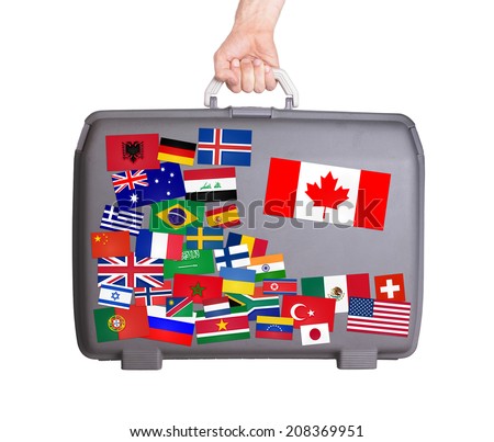Used plastic suitcase with lots of small stickers, large sticker of Canada
