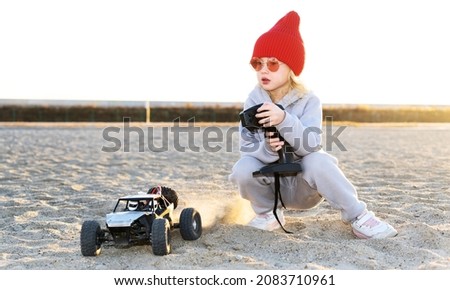 Baby girl playing speed racing rc car off road buggy vehicle toy radio controller remotely driving Royalty-Free Stock Photo #2083710961