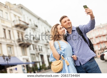 Young couple in love makes selfie on a smartphone in the city. Spending time together concept