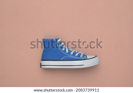 Blue high-top sneaker (gumshoe) on pink background. Top view. Minimalism Royalty-Free Stock Photo #2083739911