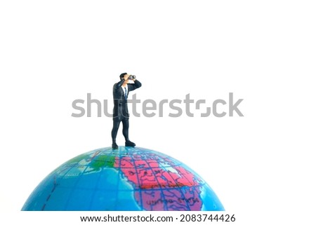 Businessmen standing using binoculars above earth globe. Miniature tiny people toys photography. isolated on white background.
