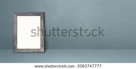 Wooden picture frame leaning on a grey wall. Blank mockup template. Horizontal banner