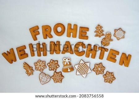Gingerbread greeting card created from honeycomb letters  on a white background, German text Frohe Weihnachten, meaning Merry Christmas, high angle view from above. Christmas decoration with wishes. 