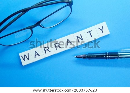 pen, glasses and word warranty on white compartment Royalty-Free Stock Photo #2083757620