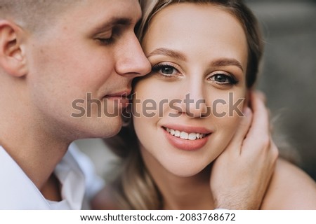 Wedding portrait, close-up photo of smiling groom and beautiful, curly blonde bride.