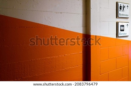 Restroom sign on the orange wall