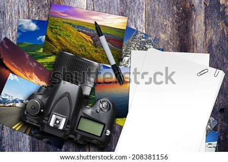 Photographer Desk Illustration with Digital Camera, Photo Prints and Blank White Papers. Aged Wood Desk Top. Top View.