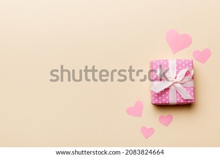 Valentine day composition: red gift box with bow and heart. Christmas present. View from above. Space for text. Holday greeting card.