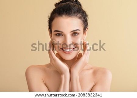 Beautiful young woman with foundation on her face against color background Royalty-Free Stock Photo #2083832341