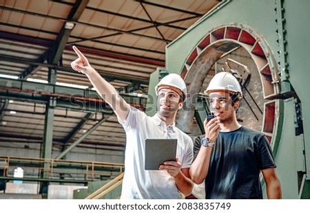 Employee and employer is in the pipe factory, they are talking about job and giving instructions. Royalty-Free Stock Photo #2083835749