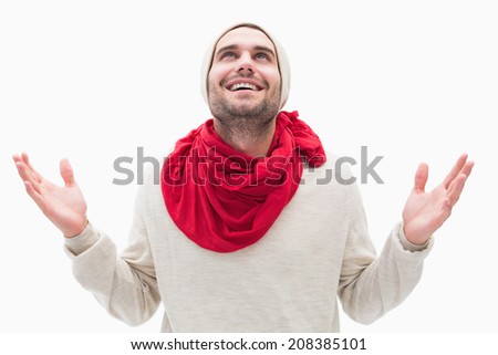 Attractive young man in warm clothes with hands up on white background