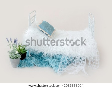 Newborn baby studio furniture bed for infant child photoshoot with fur and pillow decorated with lavander. Tiny designed scene for kid studio portrait