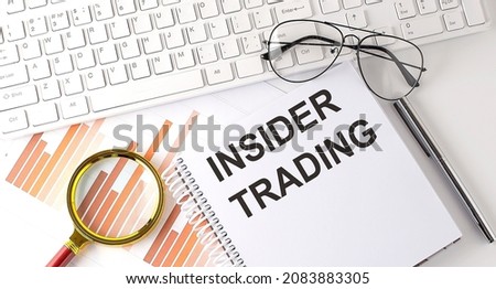 INSIDER TRADING text written on notebook with keyboard, chart,and glasses Royalty-Free Stock Photo #2083883305