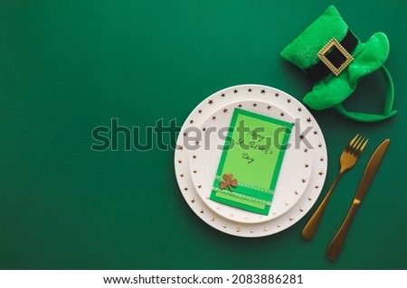 Beautiful table setting for St. Patrick's Day celebration on color background