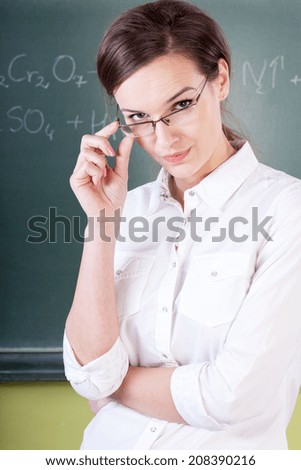 Teacher during chemistry lesson at school, vertical