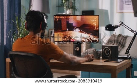 Indian gamer playing shooter at home