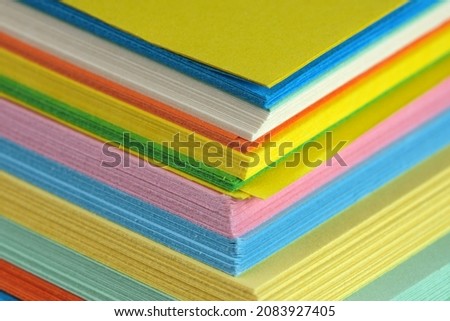 Bundle of multicolored stationery, paper background close-up