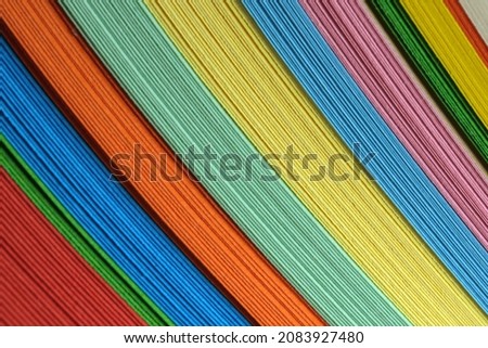 Bundle of multicolored stationery, paper background close-up