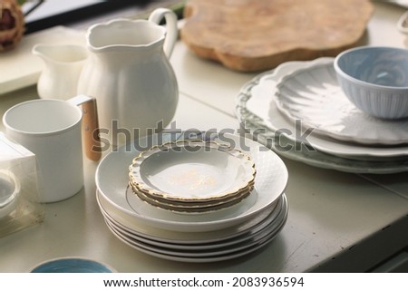 Selective focus of stacked white plates and some mug and jug, a group of food photography props 
