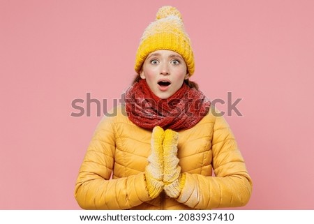 Shocked surprised young woman 20s years old wears yellow jacket hat mittens holds hands folded in prayer gesture begging about something isolated on plain pastel light pink background studio portrait Royalty-Free Stock Photo #2083937410