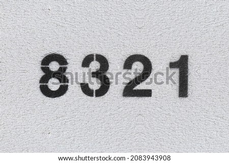 Black Number 8321 on the white wall. Spray paint. Number eight thousand three hundred and twenty one.