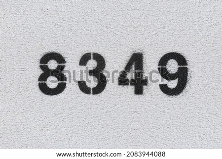 Black Number 8349 on the white wall. Spray paint. Number eight thousand three hundred forty nine.