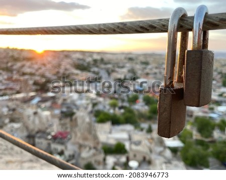 Two padlocks on the metal rope; selective focus padlocks with Cappadocia and sunset background view, selective focus