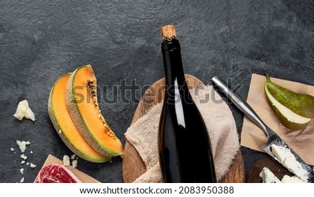 Red wine with appetizers on gray background. Traditional alcohol drinks. Top view, flat lay, copy space