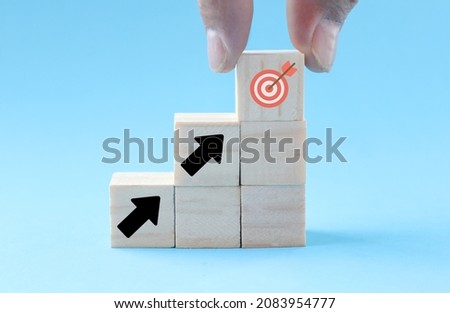 Wooden cube with arrow pointing up to the target icon. Ideas for the success of business growth