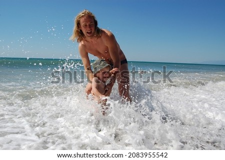 Father and little son swimming in the sea 