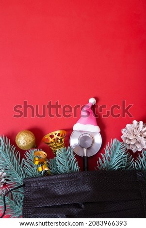 Flat lay  medical stethoscope in santa hat and christmas decorations with medical mask on red background. Medical Christmas concept with copy space