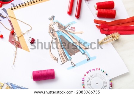 Fashion designer workplace with sketches on light background