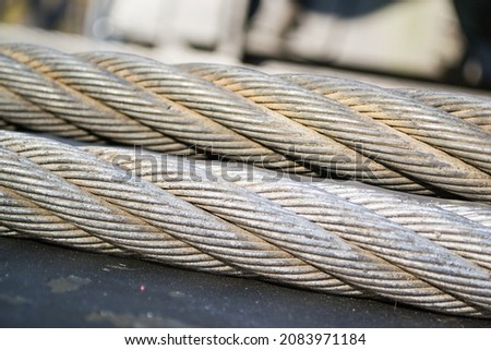 Thick steel cables with metal wires fixed in spirals forming a laid rope.