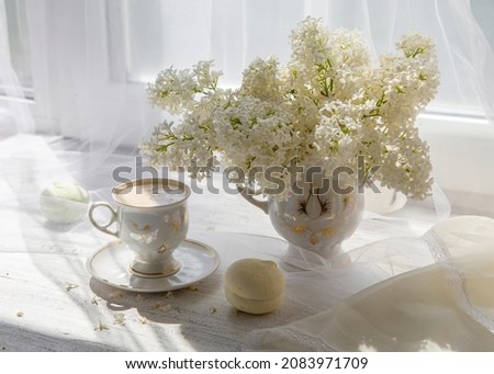 A bouquet of white lilacs and a glass with wine on the windowsill. Royalty-Free Stock Photo #2083971709