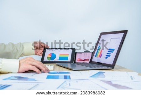 man work data graph on tablet near laptop, mobile, document with white copy space for making presentation, professional businessman busy work on the business data graph