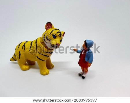 Chinese Zodiac Sign Year of Tiger.Happy Chinese New Year, Year of the Tiger. A miniature of a tiger and a little girl on a white background.