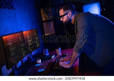 Profile portrait of smart clever professional typing keyboard look two displays testing edit dark evening loft space