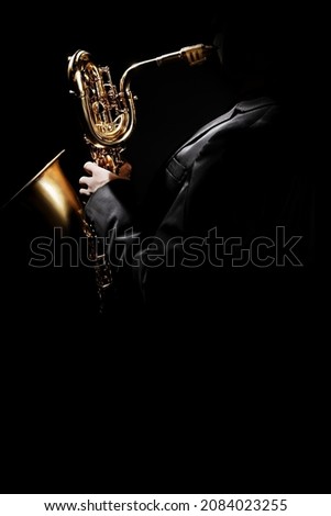 Saxophone player. Saxophonist with sax baritone. Jazzman playing jazz music instrumen isolated on black background Royalty-Free Stock Photo #2084023255