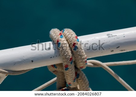 close-up nautical image, knotted rope, nickel-plated handrail