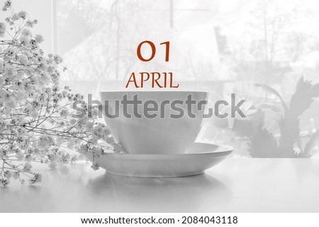 calendar date on light background with porcelain white tea pair and white gypsophila with copy space.  April 1 is the first day of the month.