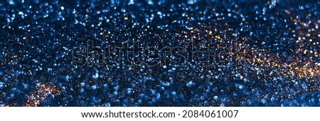 Blue and golden sparkling glitter bokeh background texture. Holiday lights. Abstract defocused header. Wide screen wallpaper. Panoramic web banner with copy space for design