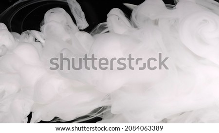 White cloud of ink. White acrylic ink in water on a black background. Beautiful milky white awesome abstract background.