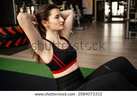 Girl stretching or yoga in gym using a laptop with online training. Young woman work outing