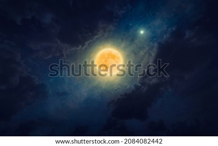 Amazing mysterious image – rising full moon in dark blue starry sky. Elements of this image furnished by NASA. Full moon party concept image. Royalty-Free Stock Photo #2084082442