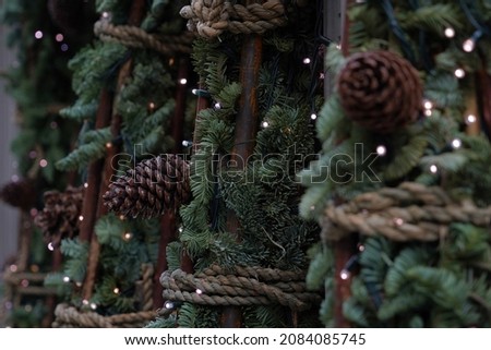 Christmas decoration made of coniferous branches with pinnacles an tiny lights attached to the branches. Seasonal theme with focus on the background.