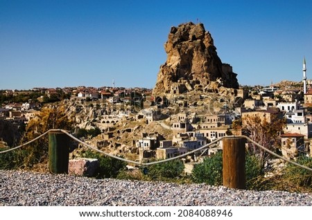 Wonderful panoramic view of ancient Ortahisar cave city. Blue sky background. Popular travel destination in Turkey. UNESCO World Heritage Site. Autumn sunny day landscape.