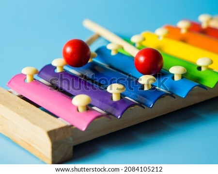 colorful educational xylophone toy on a blue background with copy space. Children's toy and musical instrument.