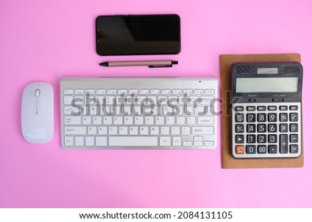 Flat lay, top view office table desk. Workspace with Laptop, office supplies, pencil, caculator, notebook, on pink background.