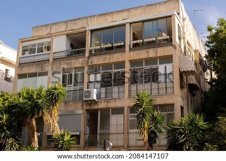 Typical Tel Avivian building in Old North district. Big open windows old facade with palms around. Tel aviv, Israel Royalty-Free Stock Photo #2084147107